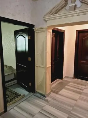 an empty room with two doors and a tile floor at zin home in ‘Awjān ash Sharqī