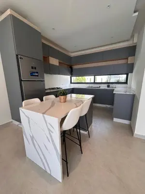 a kitchen with a table and some chairs at Shomani by Seahorse in Al Rama