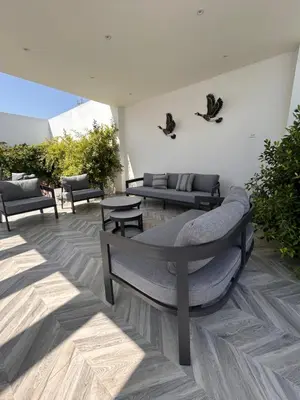 a patio with couches and tables and chairs at Shomani by Seahorse in Al Rama