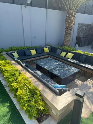 a patio with a blue couch and some plants at Maria La Rosa By Seahorse in Al Baḩḩāth