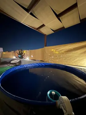 a hot tub on the roof of a building at night at Rooftop pool with terraces F-R in Amman