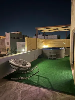 a patio with a chair on the roof at night at Rooftop pool with terraces F-R in Amman