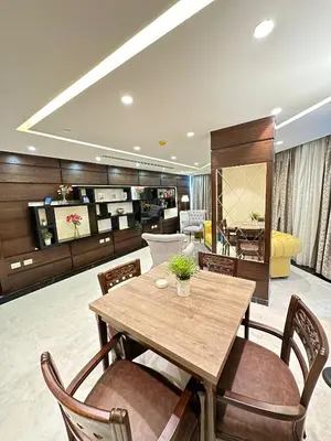 a living room with a wooden table and chairs at Londrina Hotel in Amman