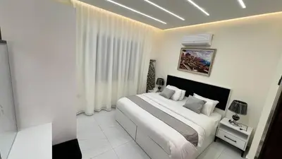 a white bedroom with a large bed in a room at شقة مفروشة فخمة بغرفتين نوم عمو سامي in Amman