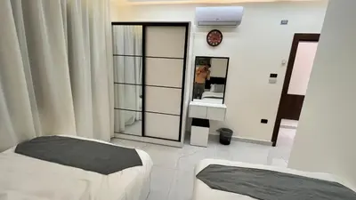 a bedroom with two beds and a large mirror at شقة مفروشة فخمة بغرفتين نوم عمو سامي in Amman