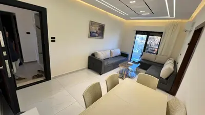a living room with a couch and a table at شقة مفروشة فخمة بغرفتين نوم عمو سامي in Amman