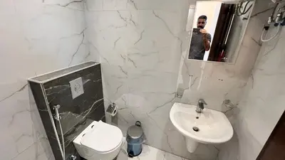 a man taking a picture of a white bathroom at شقة روف بعرفتين اطلالة ساحرة عمو سامي 21 in Amman