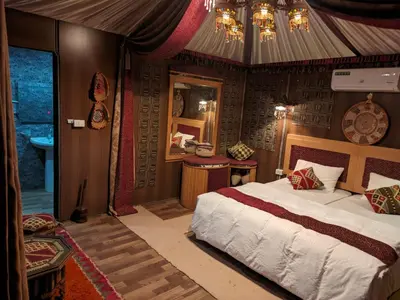 a bedroom with a large bed in a room with at Desert Sand Camp in Disah