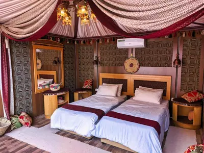 a bedroom with two beds and a mirror at Desert Sand Camp in Disah