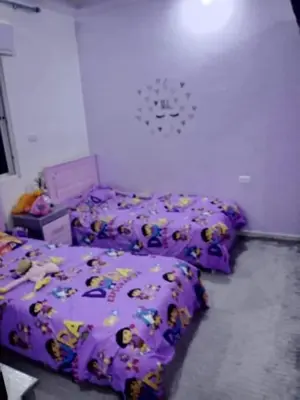 a bedroom with three beds with hello kitty comforters at olga 300 apertment in Ar Ramthā