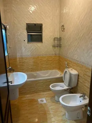 a bathroom with a toilet and a sink and a tub at olga 300 apertment in Ar Ramthā