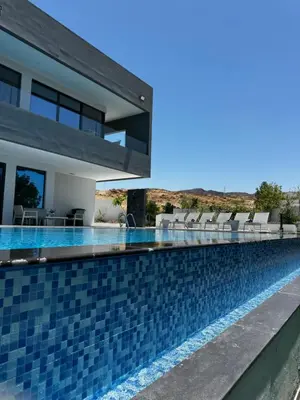 a swimming pool in a villa with a house at Beit Elhala Villa By Seahorse in Al Rama