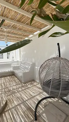 a room with a rattan chair and a table at The Greek Village - Paros By Seahorse in Sowayma