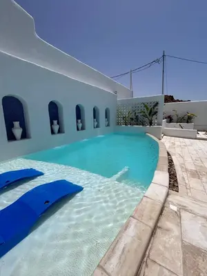 a swimming pool in the middle of a house at The Greek Village - Paros By Seahorse in Sowayma