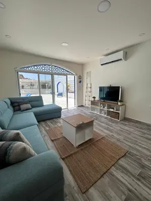 a living room with a blue couch and a tv at The Greek Village - Milos By Seahorse in Sowayma