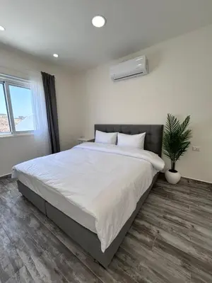 a bedroom with a large bed and a potted plant at The Greek Village - Cofru By Seahorse in Sowayma