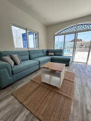 a living room with a blue couch and a coffee table at The Greek Village - Cofru By Seahorse in Sowayma