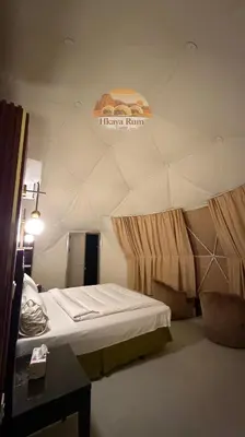 a room with a bed and a sign on the wall at Hkaya Rum camp in Wadi Rum