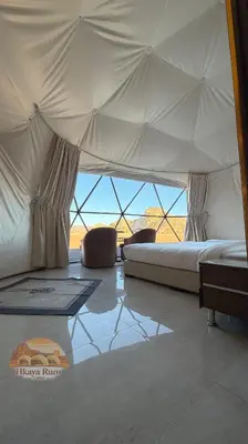a bedroom with a bed and a view of the ocean at Hkaya Rum camp in Wadi Rum