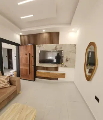 a living room with a couch and a mirror at شقة مفروشة بغرفتين نوم وصالة و حمامين in Amman