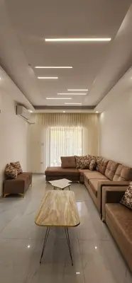 a living room with a couch and a coffee table at شقة مفروشة بغرفتين نوم وصالة و حمامين in Amman