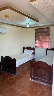 a room with two beds and a chair in it at Ali with the stars in Wadi Rum