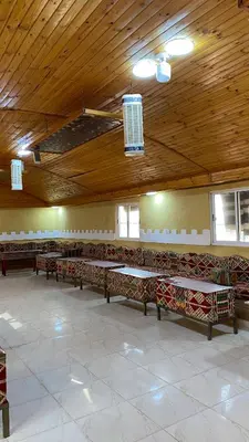 a room with tables and benches in a building at Ali with the stars in Wadi Rum