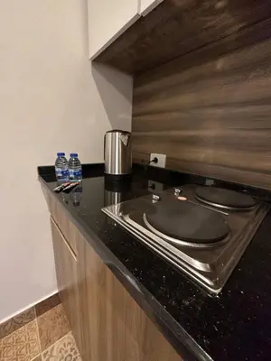 a kitchen with a counter with a sink and water bottles at 1 Antica Jabalal-lwebdeh in Amman