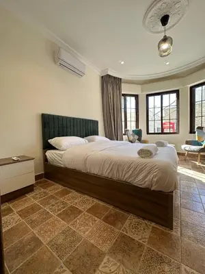 a bedroom with a large bed in a room at 1 Antica Jabalal-lwebdeh in Amman