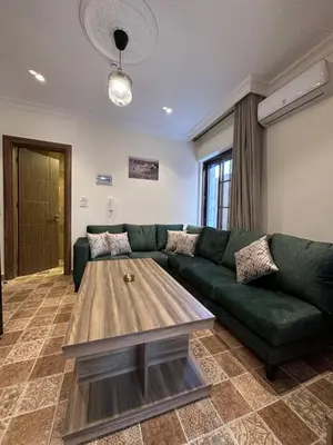 a living room with a green couch and a coffee table at 1 Antica Jabalal-lwebdeh in Amman