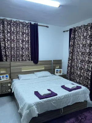 a bedroom with a large bed with purple towels on it at Jarash in Jerash