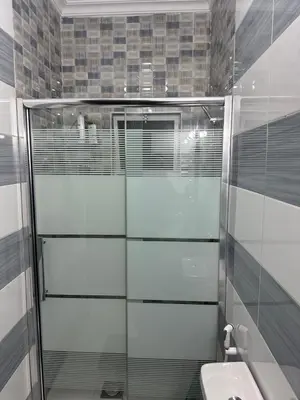 a bathroom with a shower and a toilet and a sink at Airport Road شارع المطار in Al Yādūdah