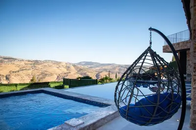 a swing hanging over a swimming pool at Makanak Villas in Jerash