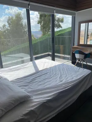 a bed in a bedroom with a large window at Makanak Villas in Jerash