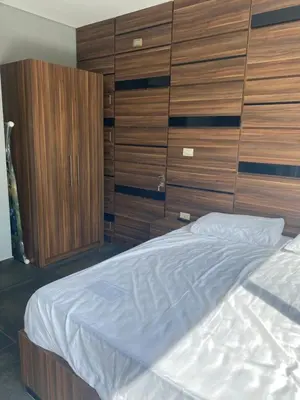 a bedroom with a large bed and wooden cabinets at Makanak Villas in Jerash