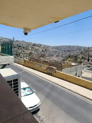 a white car parked on the side of a street at Loft Apartment Jabal Amman A in Amman