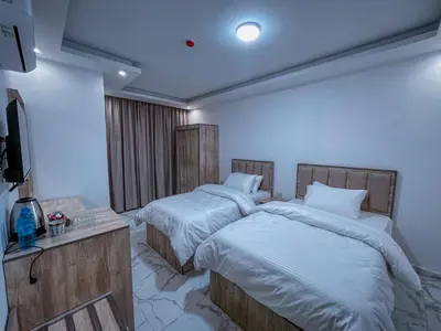 a bedroom with two beds and a flat screen tv at Petra Friends House in Petra