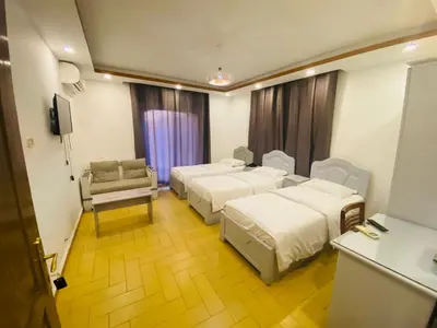 a hotel room with three beds and a couch at فندق اربد بلازا in Irbid