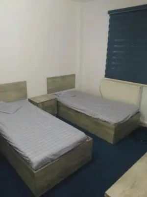 three beds are lined up in a room at soon inn in Petra