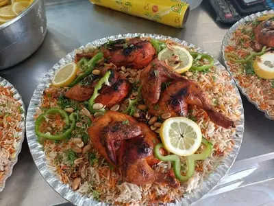 a plate of food with chicken and rice and lemon slices at soon inn in Petra