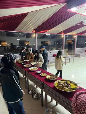 a group of people standing around a table with food at Magic mountains rum in Wadi Rum