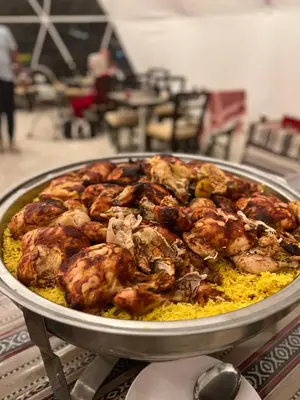 a pan of food with chickens on top of yellow rice at Magic mountains rum in Wadi Rum