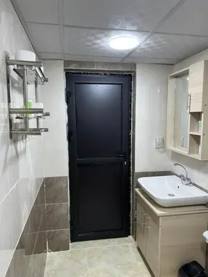 a black door in a bathroom with a sink at Magic mountains rum in Wadi Rum