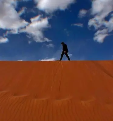 a man walking on top of a sand hill at Wadi rum magical in Wadi Rum