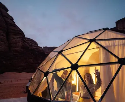 a man and a woman standing inside a glass igloo at RADISSON lUXURY RUM CAMP in Wadi Rum