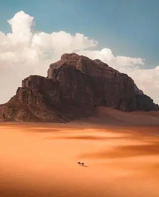 a mountain with two people on planes in the desert at RADISSON lUXURY RUM CAMP in Wadi Rum