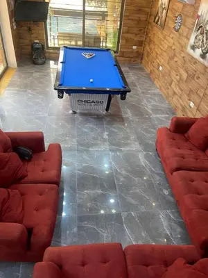 a pool table in a living room with two couches at Yasmina Chalet in Al Kafrayn