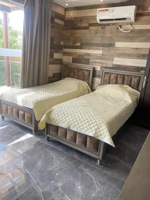 two beds sitting next to each other in a bedroom at Yasmina Chalet in Al Kafrayn