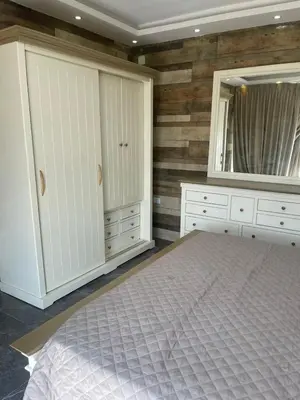 a bedroom with a bed and a large mirror at Yasmina Chalet in Al Kafrayn