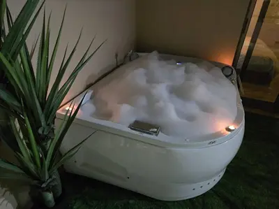 a white bath tub sitting next to a potted plant at Jumeirah Chalet جميرا شاليه in Amman